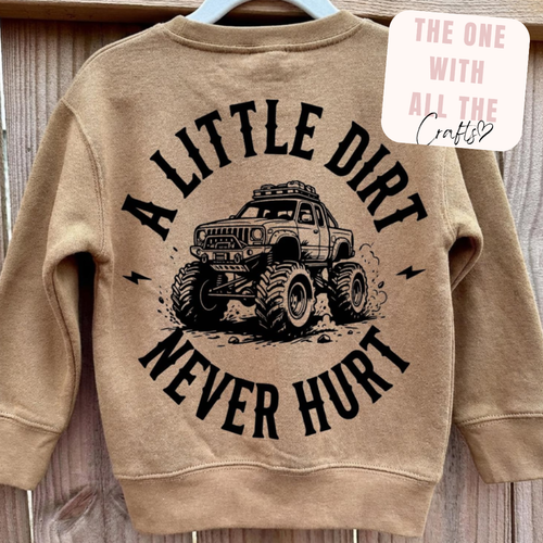 Beige sweatshirt with graphic of a truck and text 'A LITTLE DIRT NEVER HURT' on a wooden background.