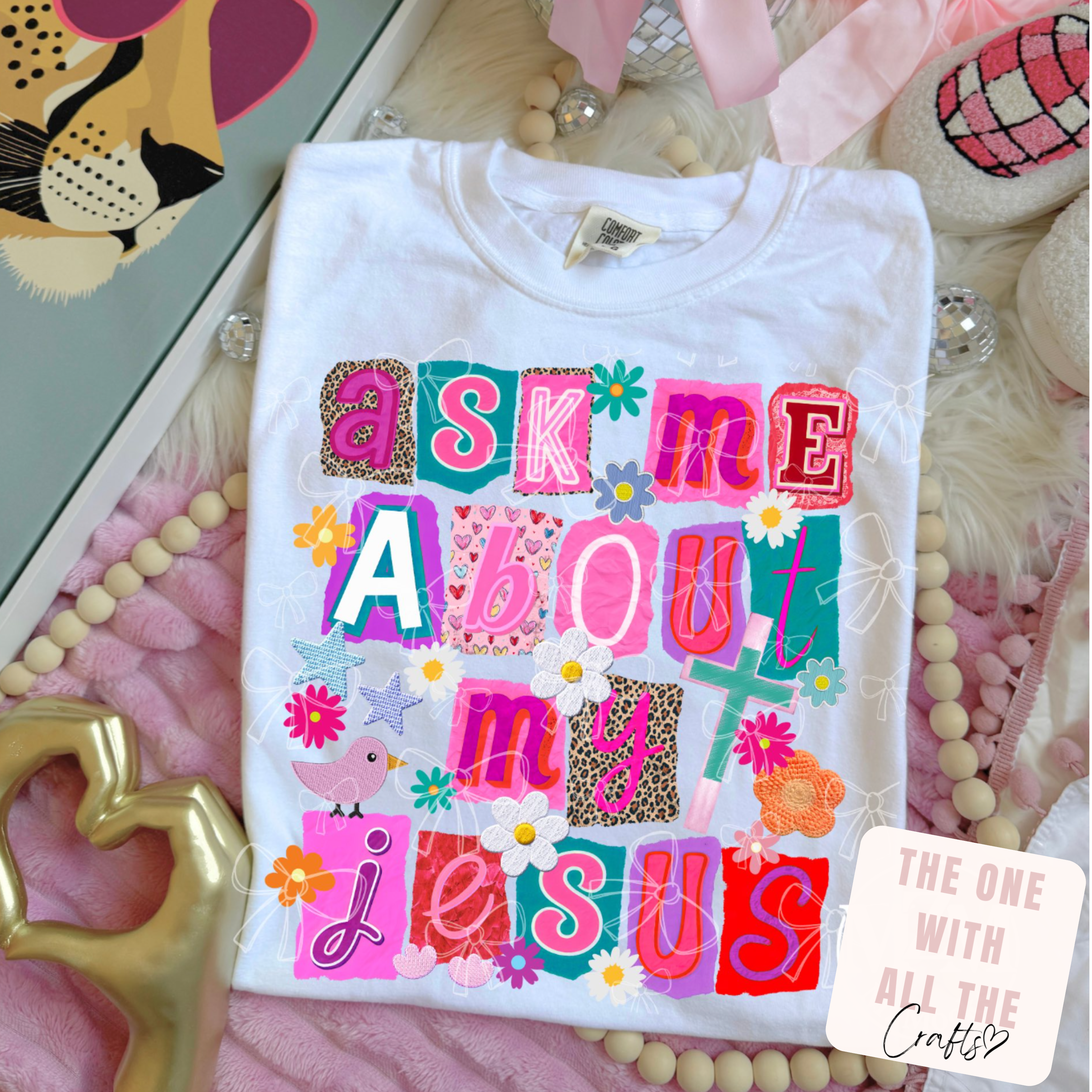 White t-shirt with colorful text design on a decorative surface