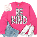 Pink sweatshirt with 'BE KIND' text, jeans, and white sneakers on a white background
