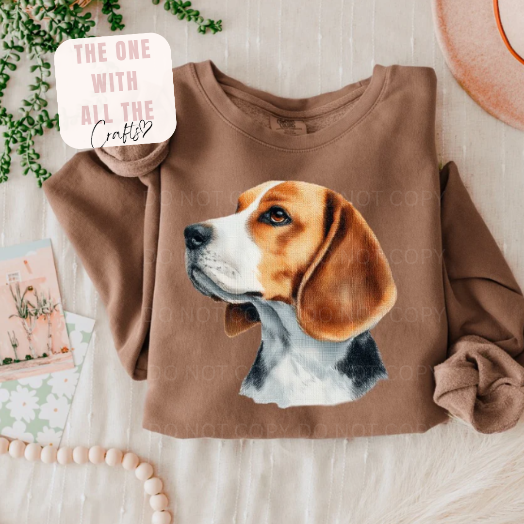 Brown sweatshirt with a dog graphic on a light wooden surface