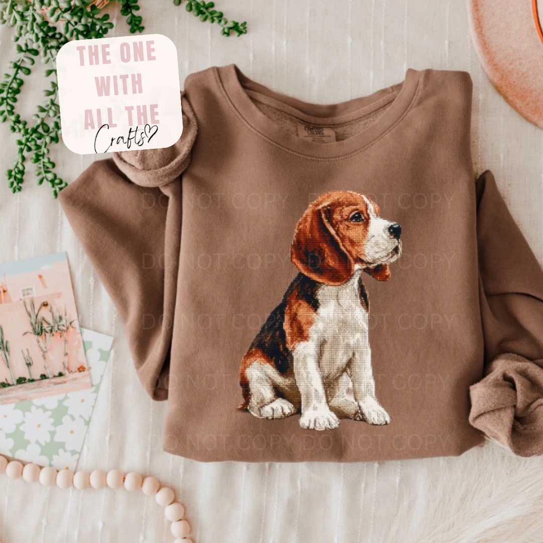 Brown sweatshirt with a dog graphic on a light wooden surface.