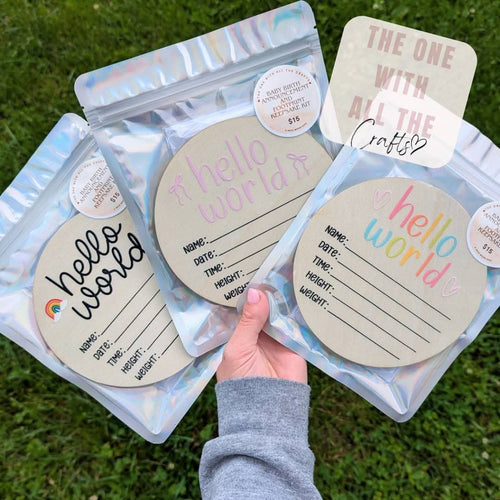 Packages with 'hello world' labels held by a person against a grass background