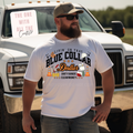Man wearing a white t-shirt with a graphic design in front of a truck