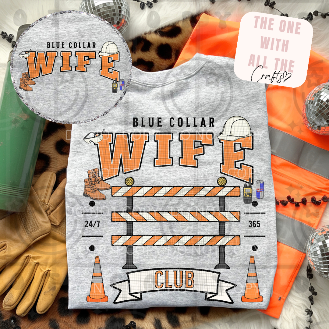 T-shirt with 'Blue Collar Wife' design on a textured surface with construction-themed accessories.