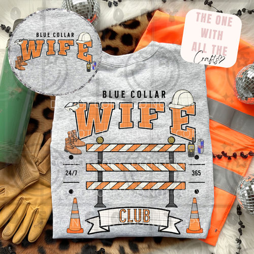T-shirt with 'Blue Collar Wife' design on a textured surface with construction-themed accessories.