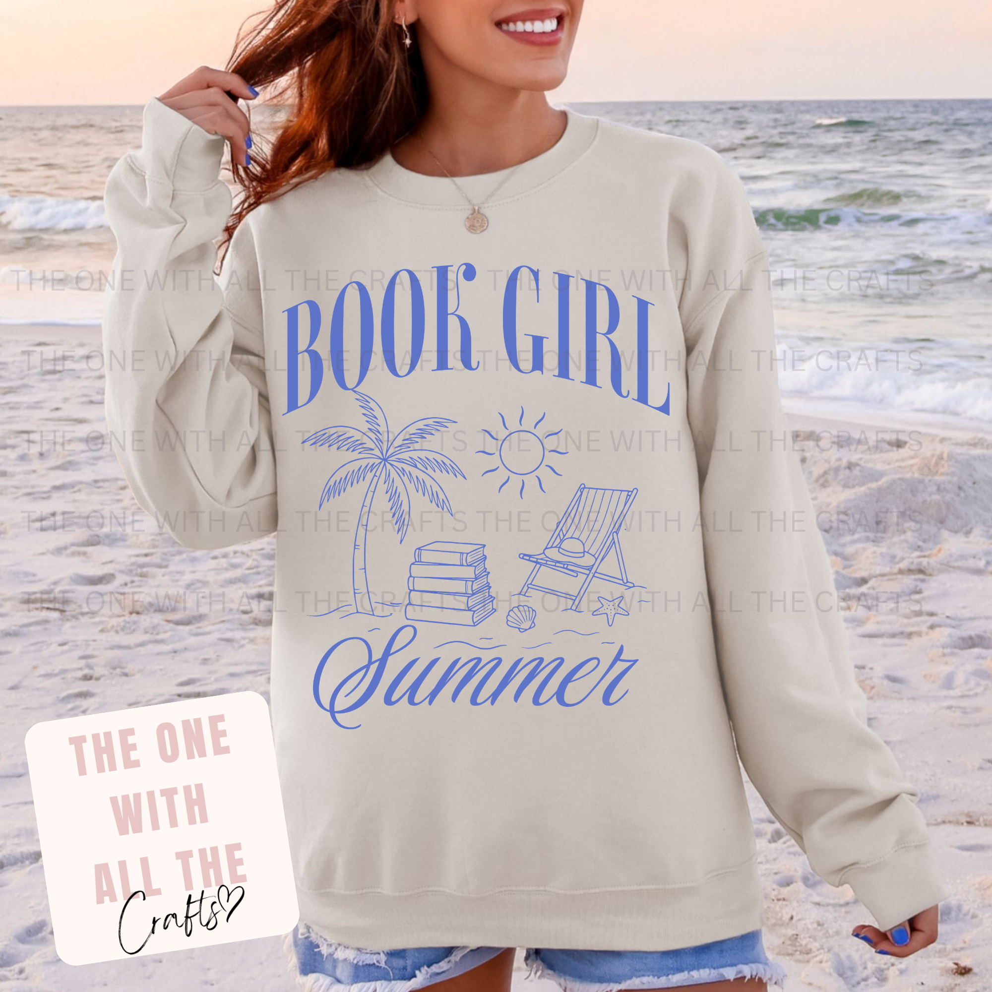 Person wearing a 'Book Girl Summer' sweatshirt on a beach.