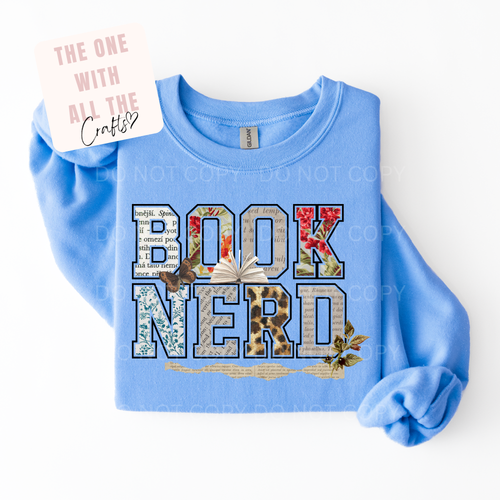 Blue sweatshirt with 'BOOK NERD' text and decorative elements on a white background
