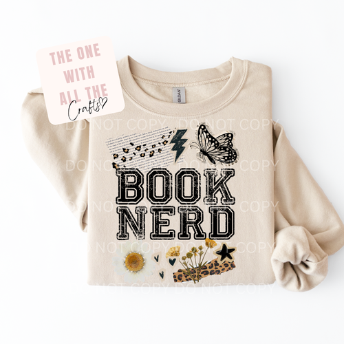 Beige sweatshirt with 'BOOK NERD' text and decorative elements on a white background
