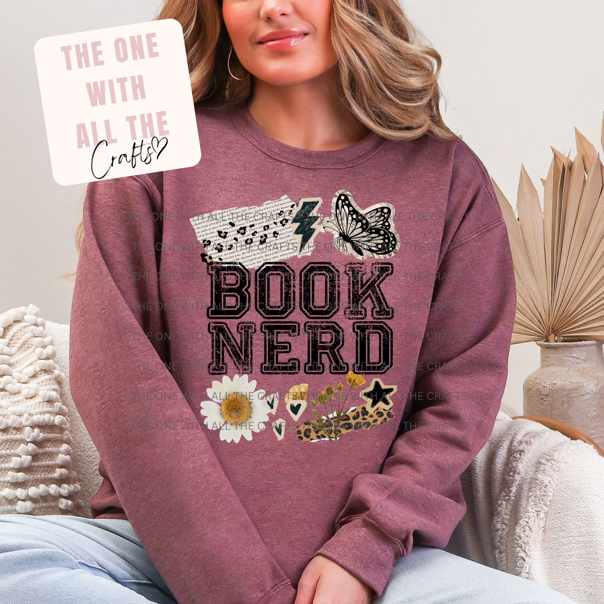 Person wearing a maroon sweatshirt with 'BOOK NERD' design, sitting on a couch.