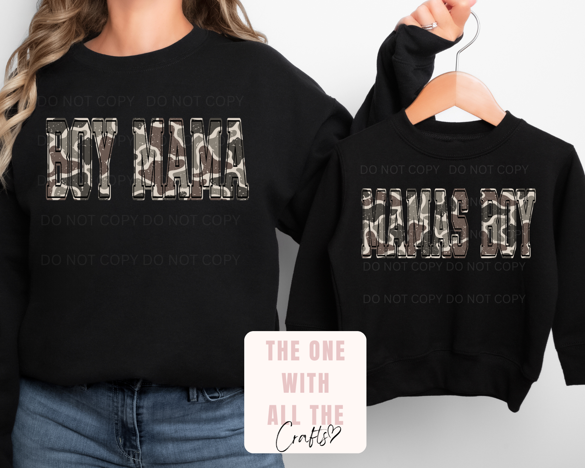 Black sweatshirts with 'BOY MAMA' and 'MAMA BOY' text, worn by a person and on a hanger.