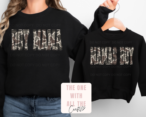 Black sweatshirts with 'BOY MAMA' and 'MAMA BOY' text, worn by a person and on a hanger.
