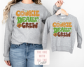 Gray sweatshirts with 'Cookie Dealer Crew' text, one worn by a person, the other on a hanger.