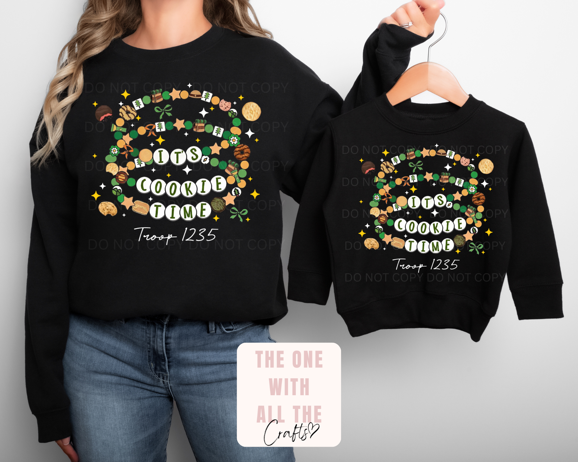 Black sweatshirts with decorative text and graphics, one on a person and one on a hanger.