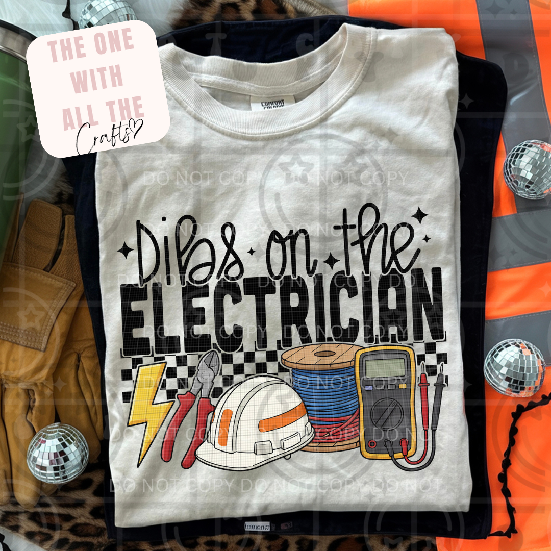 T-shirt with 'Dibs on the Electrician' text and electrician-themed graphics, surrounded by disco balls and a leopard print item.