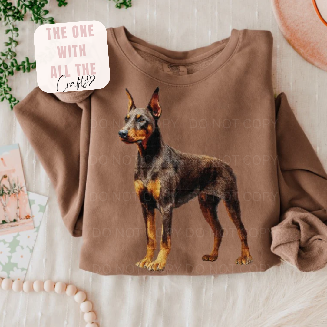Brown sweatshirt with a dog graphic on a light wooden surface.