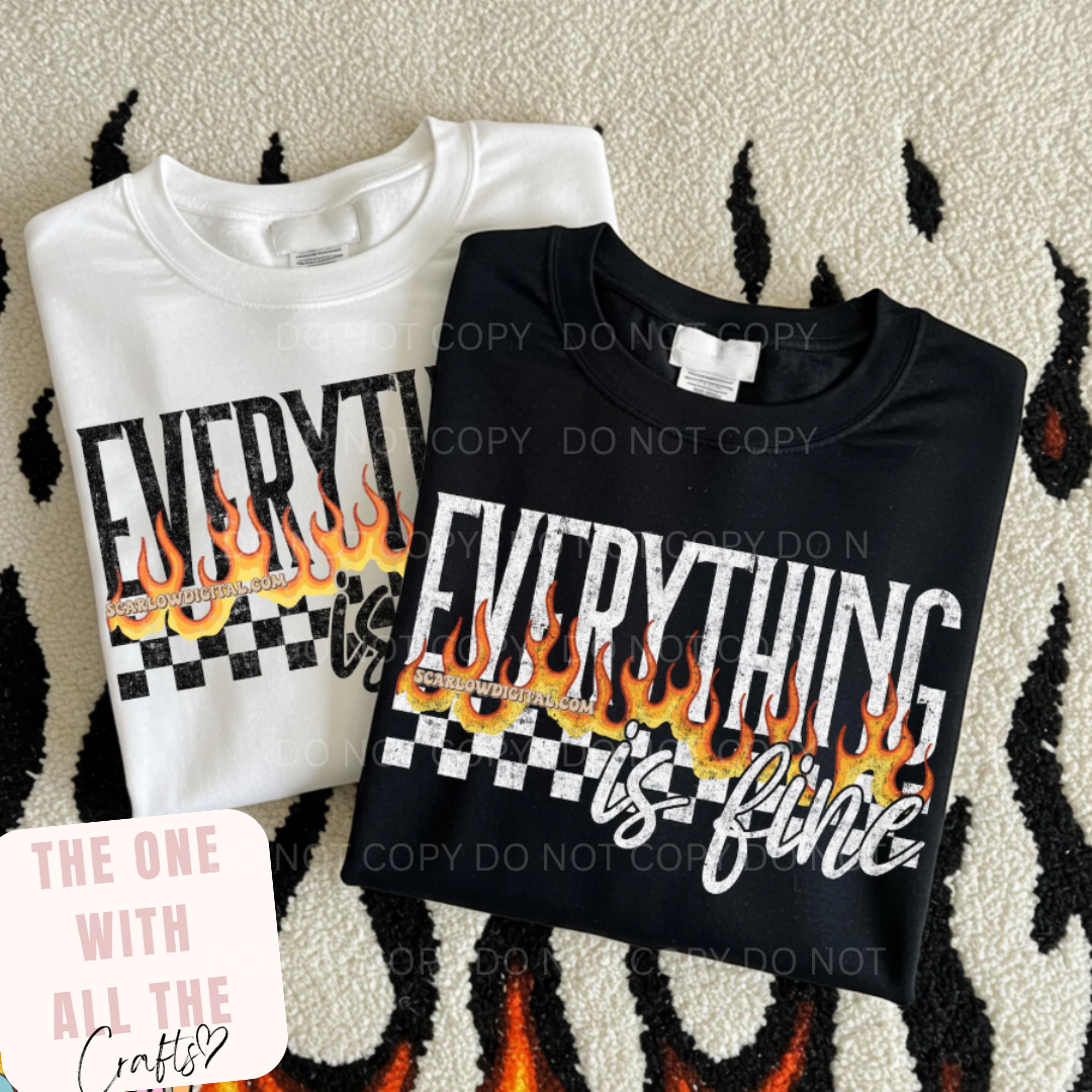 Two folded shirts with 'Everything is fine' text and flames design on a textured surface.