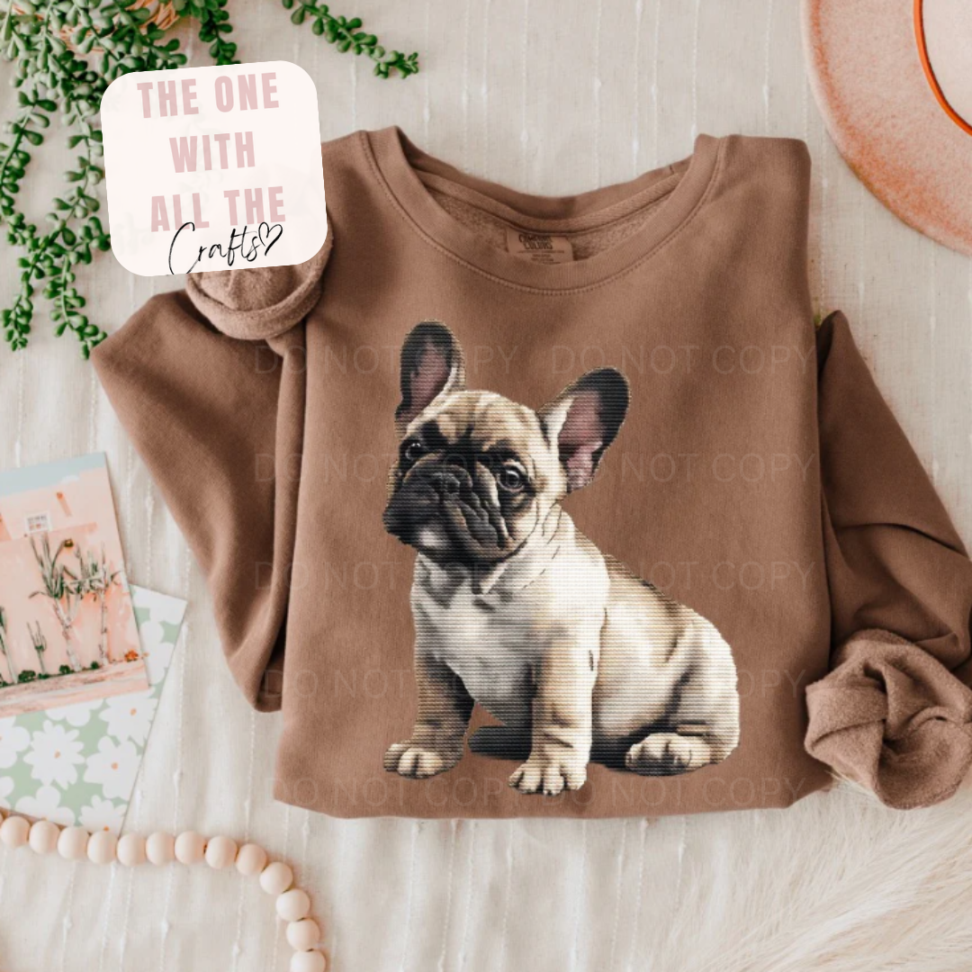 Brown sweatshirt with a dog graphic on a light wooden surface