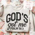 White sweatshirt with 'God's got me Psalm 56:3' text on a colorful surface.