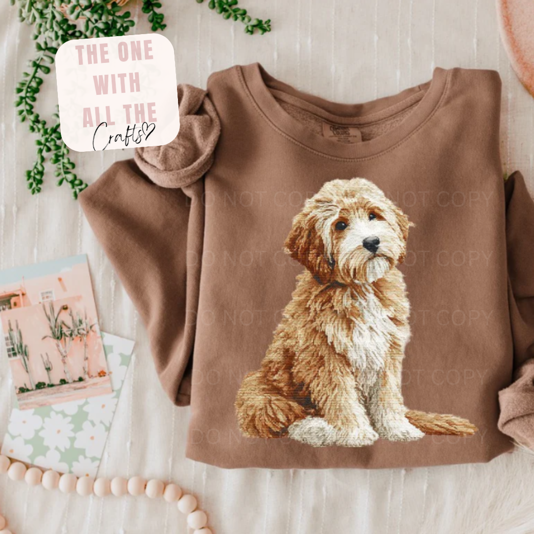 Brown sweatshirt with a dog graphic on a light wooden surface.
