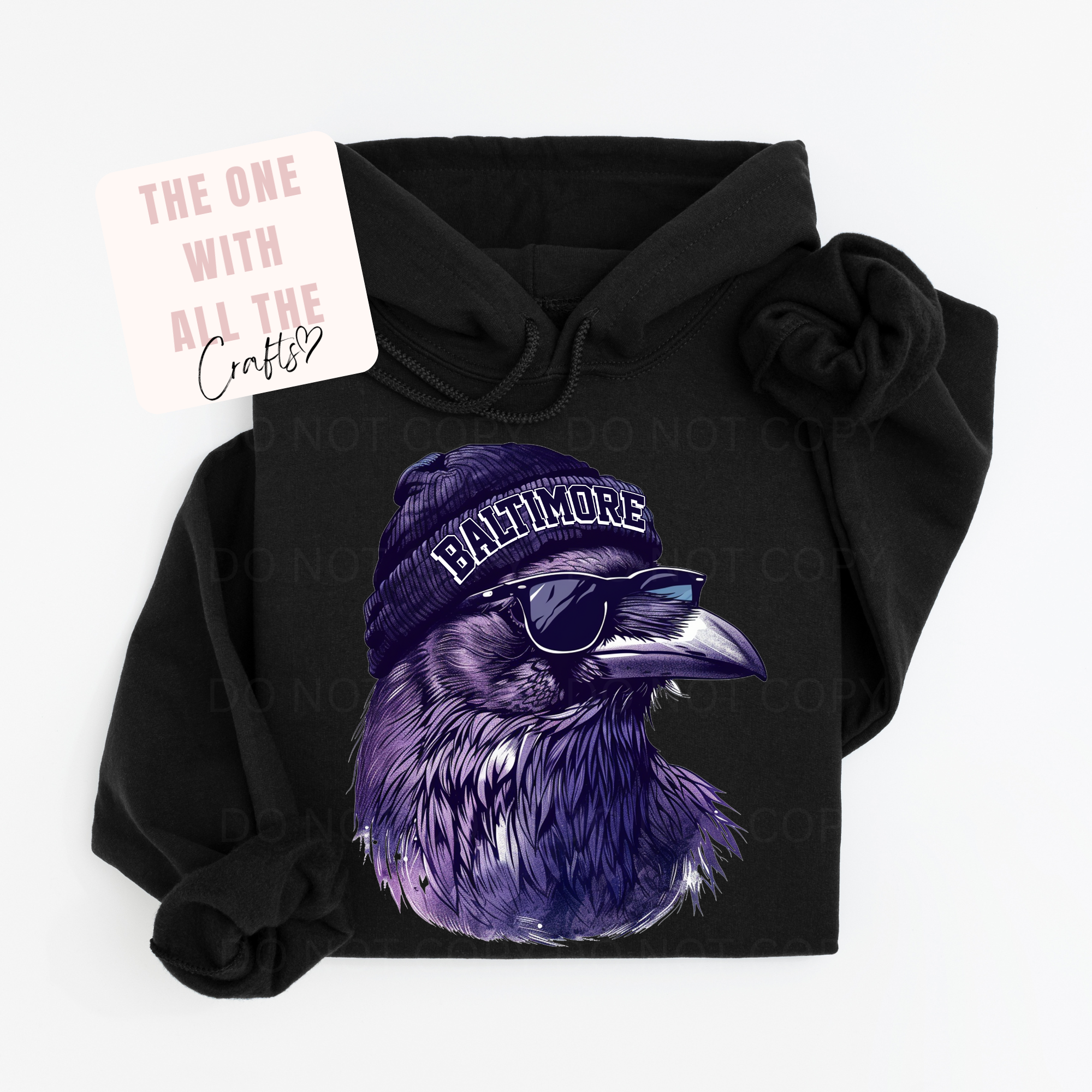 Black hoodie with a purple bird graphic wearing a 'Baltimore' hat on a white background