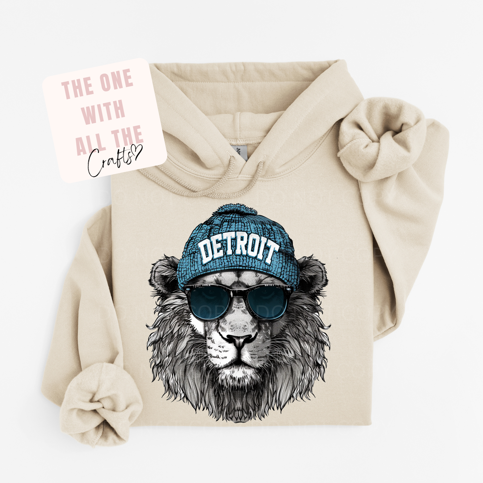 Beige hoodie with a lion wearing a 'Detroit' cap and sunglasses design, on a white background.