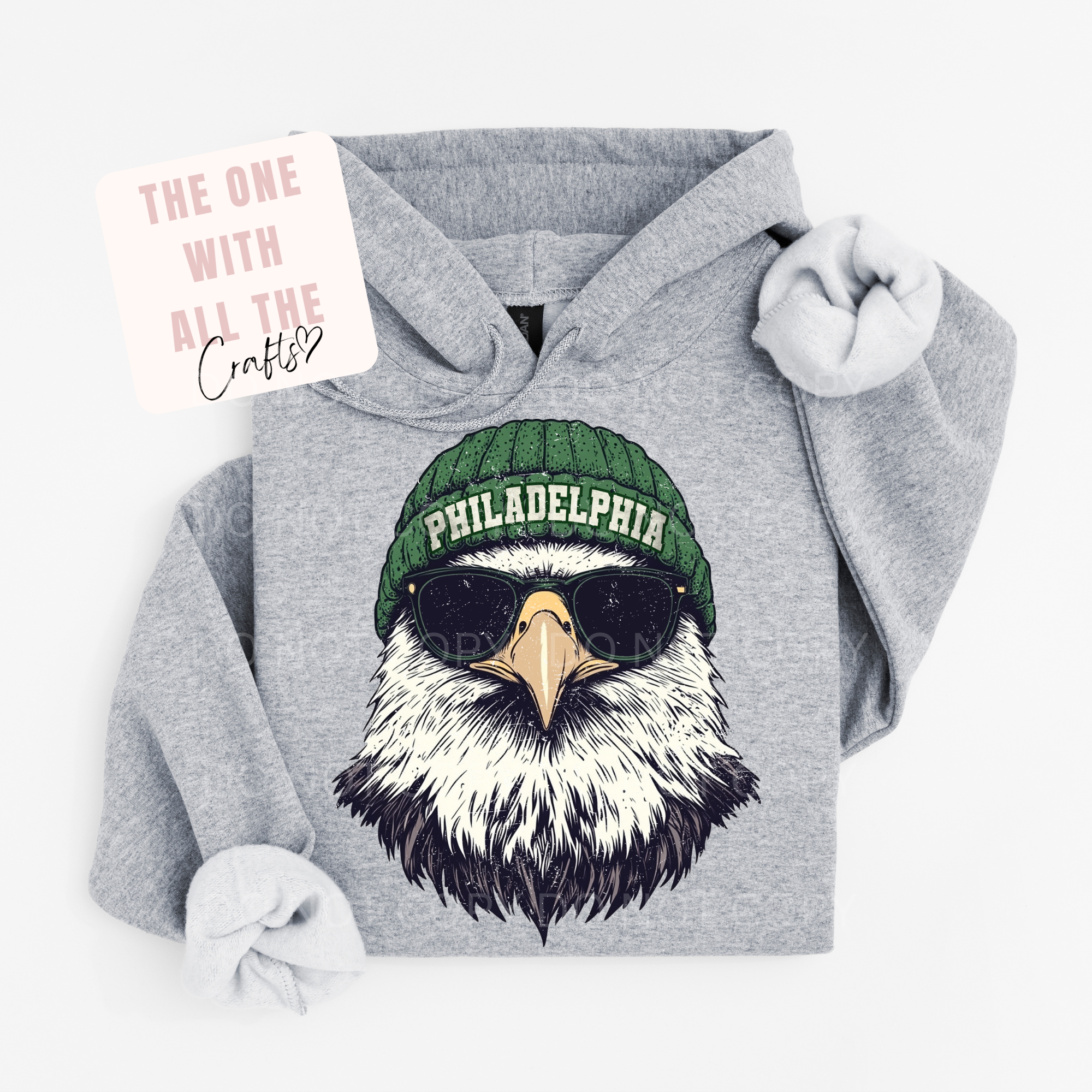 Gray hoodie with an eagle design wearing a green 'Philadelphia' beanie on a white background