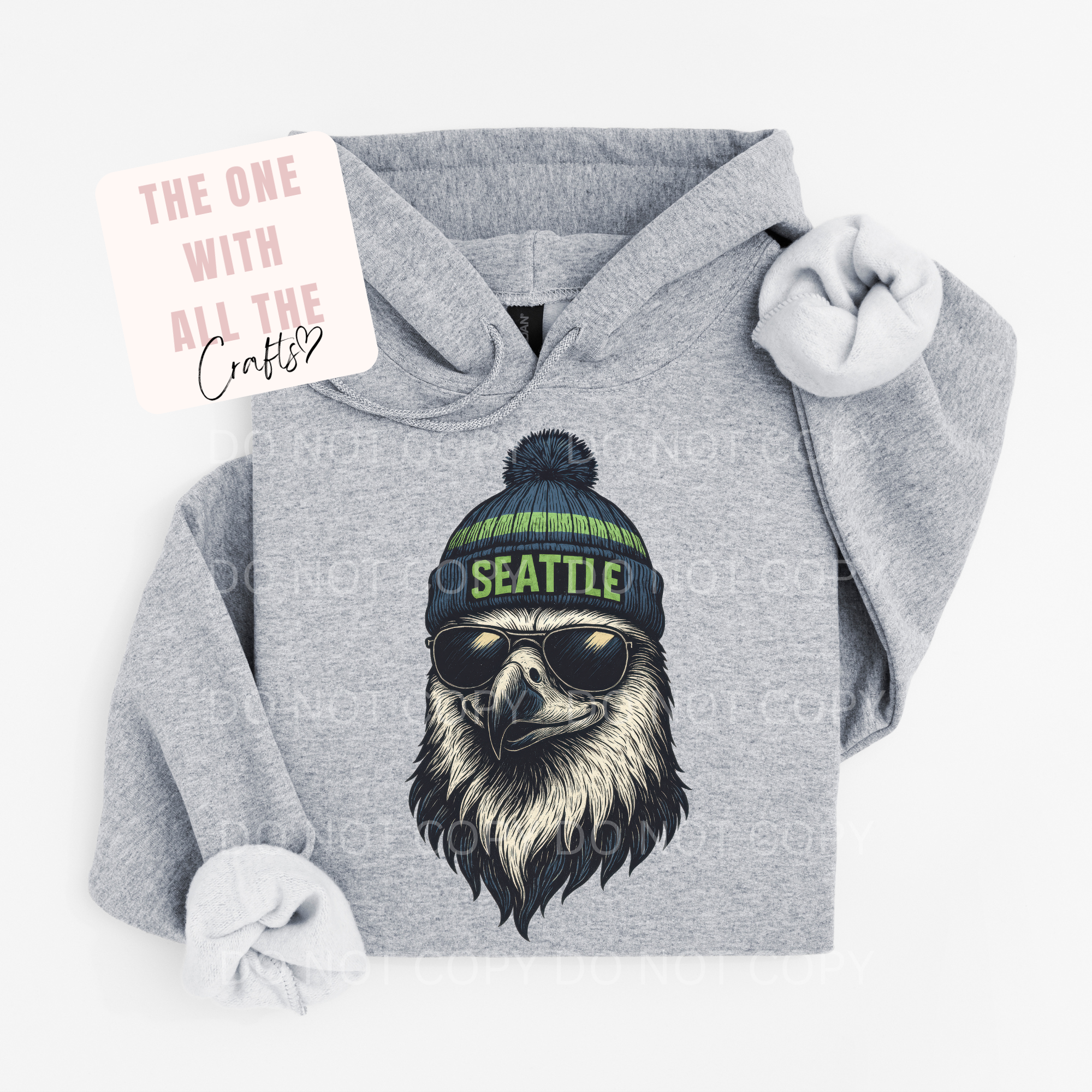 Gray hoodie with an eagle design wearing a 'Seattle' beanie on a white background
