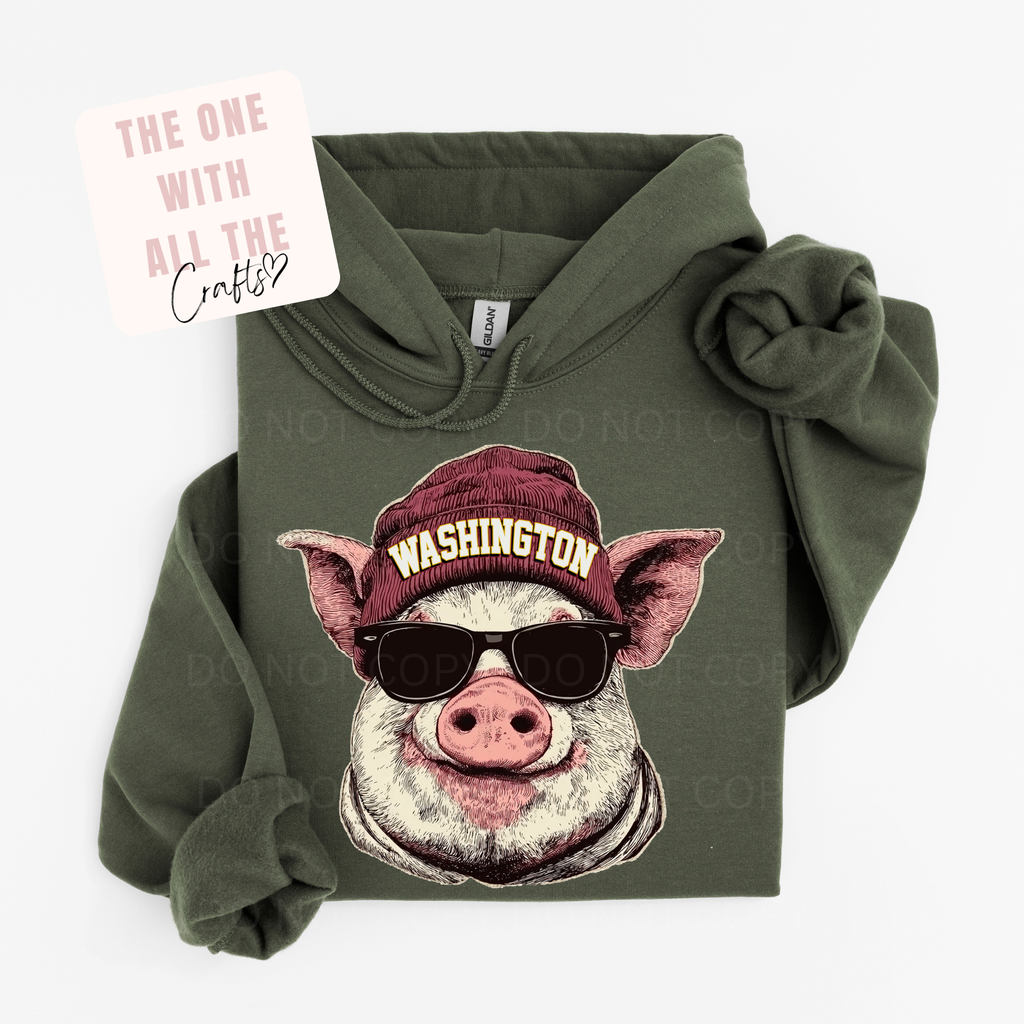 Green hoodie with a pig wearing sunglasses and a 'Washington' hat design on a white background.