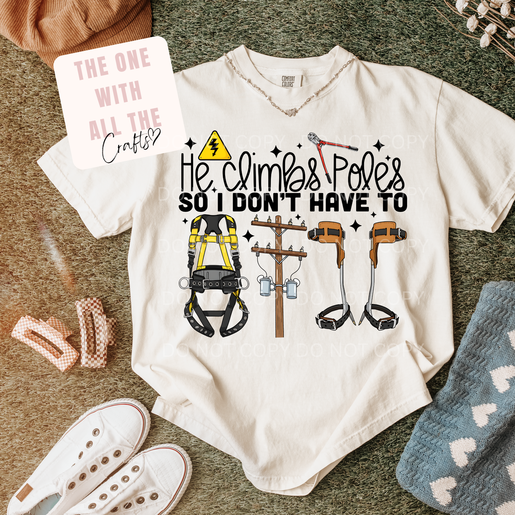 White t-shirt with graphic design and text, surrounded by accessories on a textured surface.