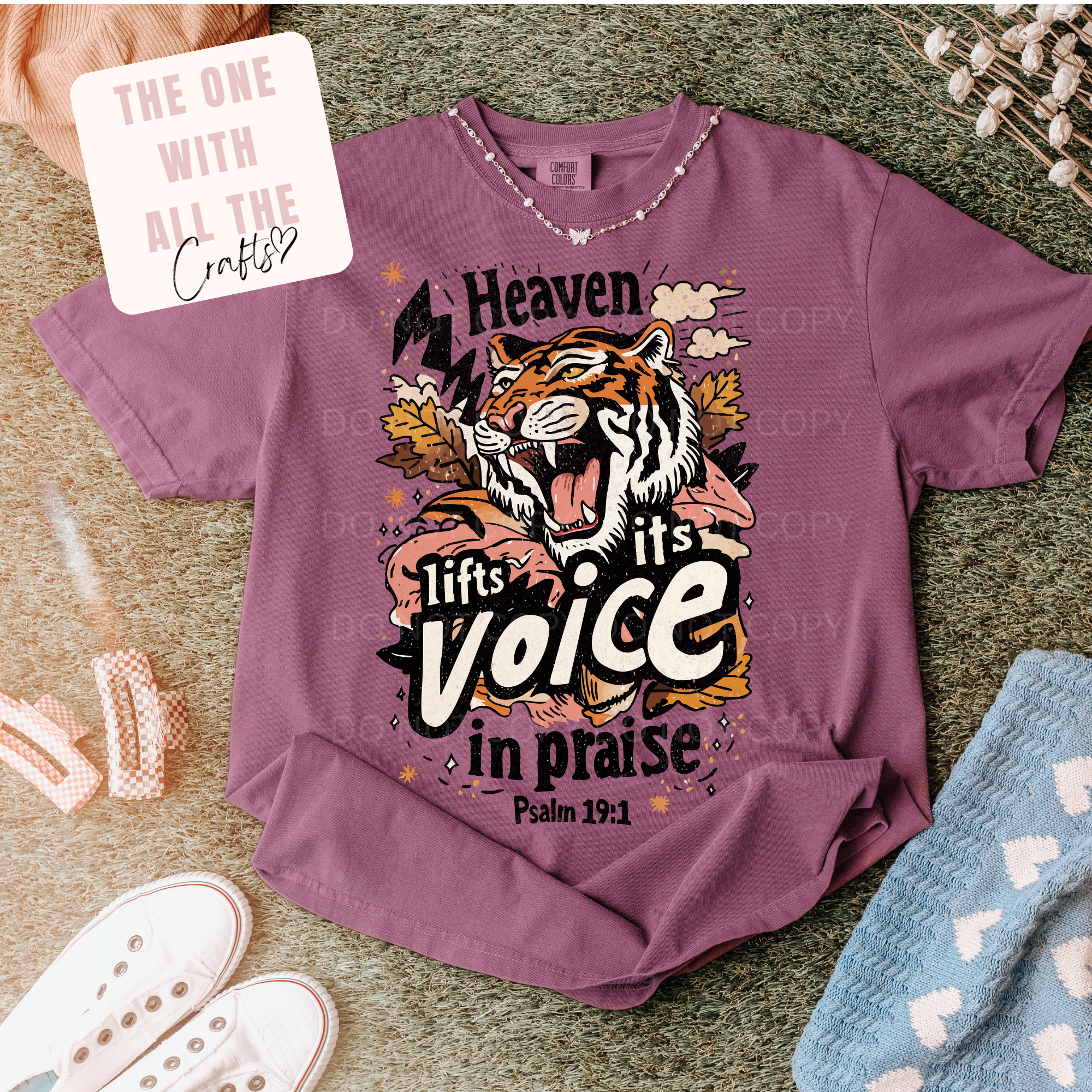 Purple t-shirt with a tiger graphic and text on a textured surface