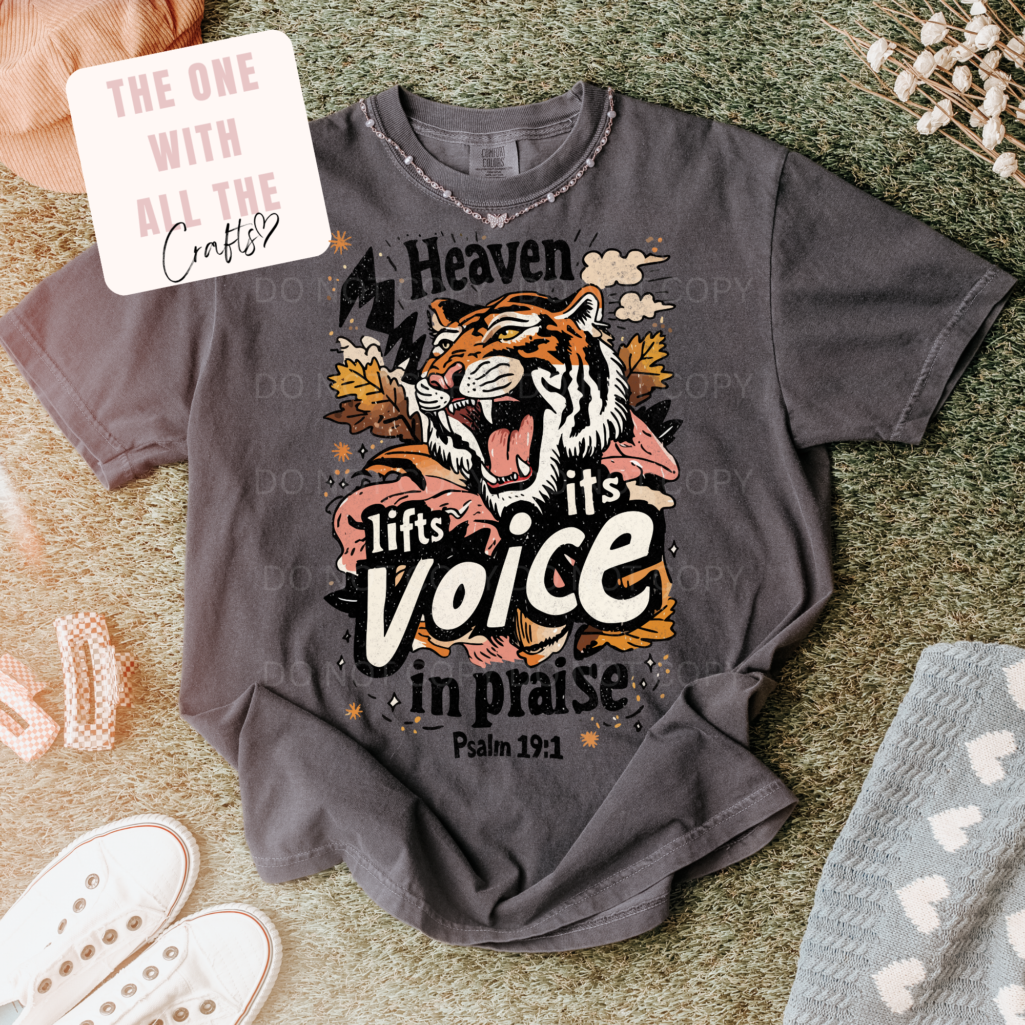 Gray t-shirt with a tiger graphic and text on a textured surface