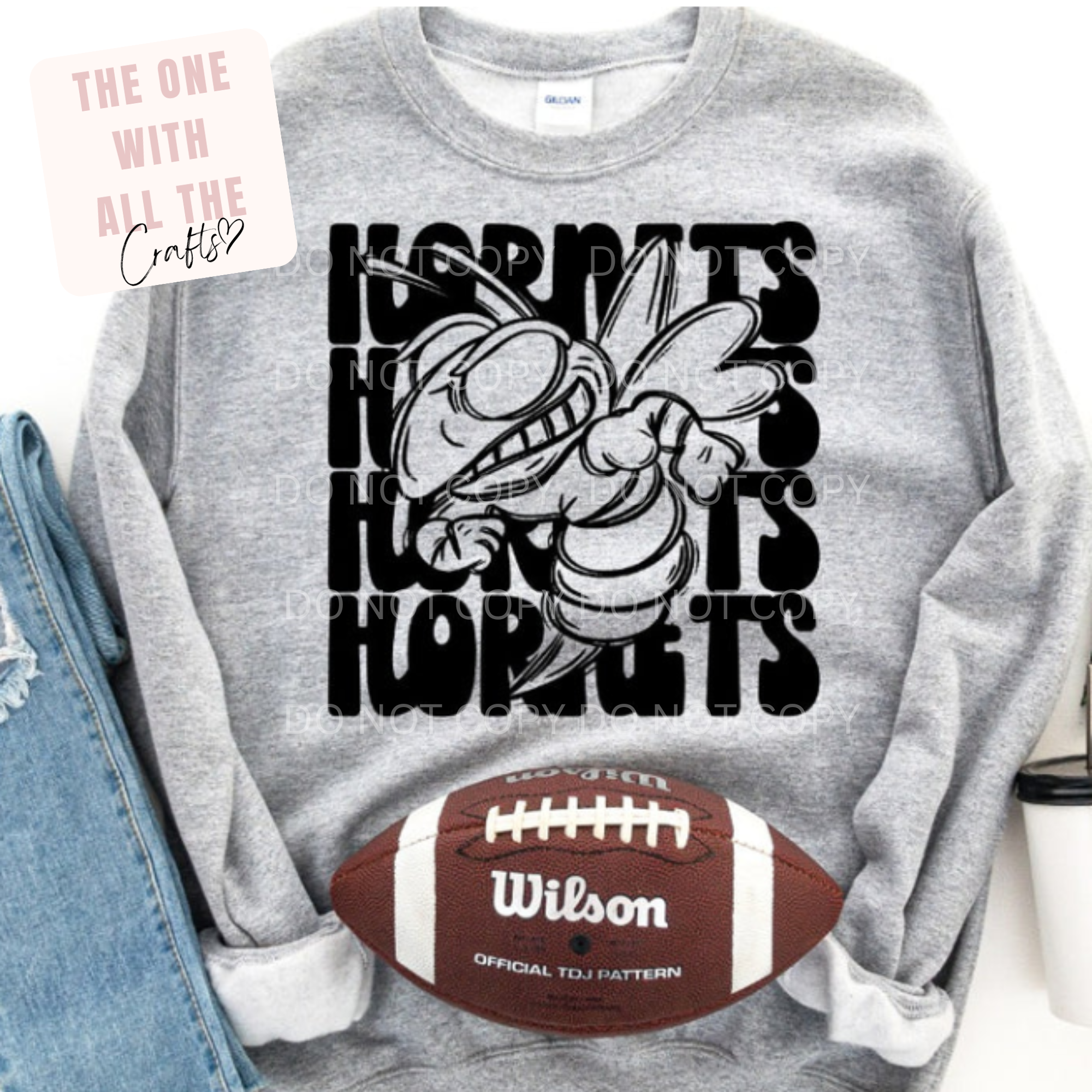 Gray sweatshirt with a cartoon character and text, next to a Wilson football.