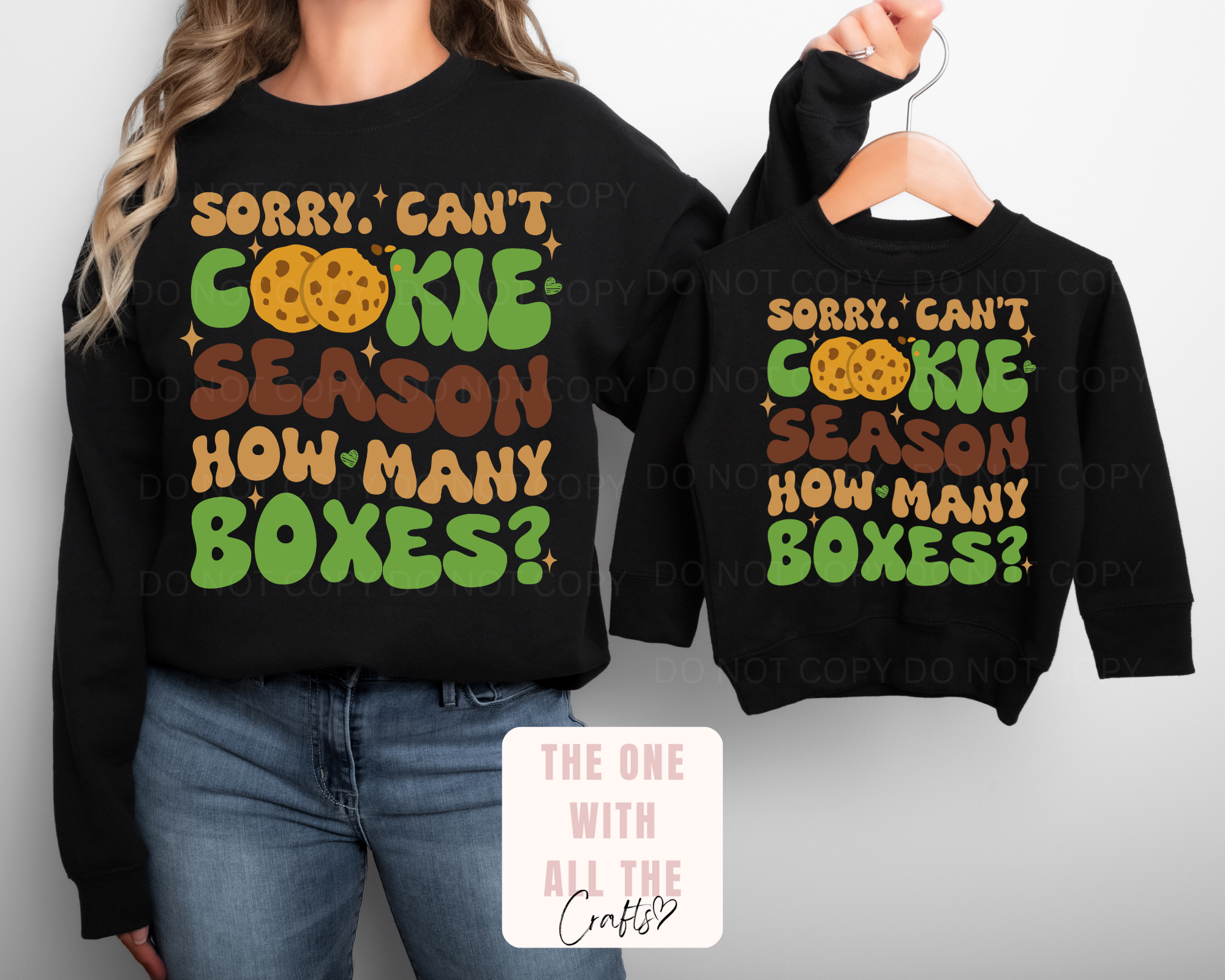 Black sweatshirts with colorful text design on a plain background