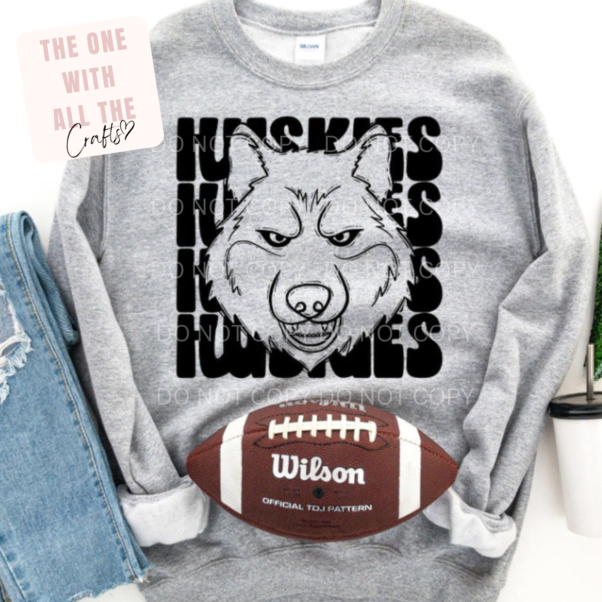 Gray sweatshirt with a wolf graphic and 'Huskies' text, next to a Wilson football.