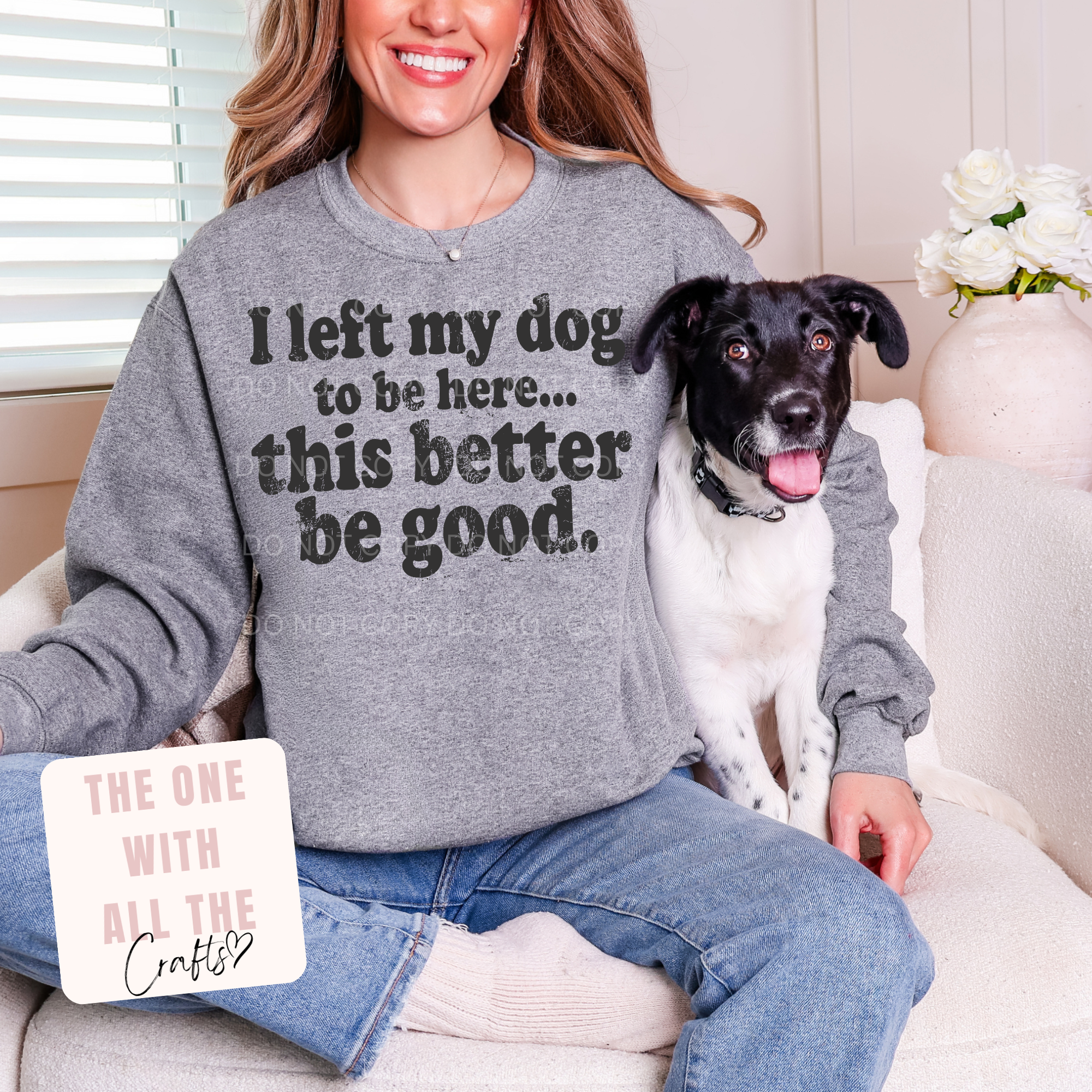 Woman wearing a gray sweatshirt with a dog sitting on her lap, both smiling.
