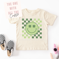 Beige t-shirt with green smiley face design on a white background
