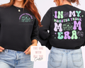 Black sweatshirt with 'In My Monster Truck Mama Era' text and graphics on front and back, worn by a person.