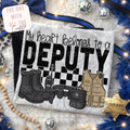 Decorative pillow with 'My heart belongs to a deputy' text and police-themed illustrations on a soft surface.