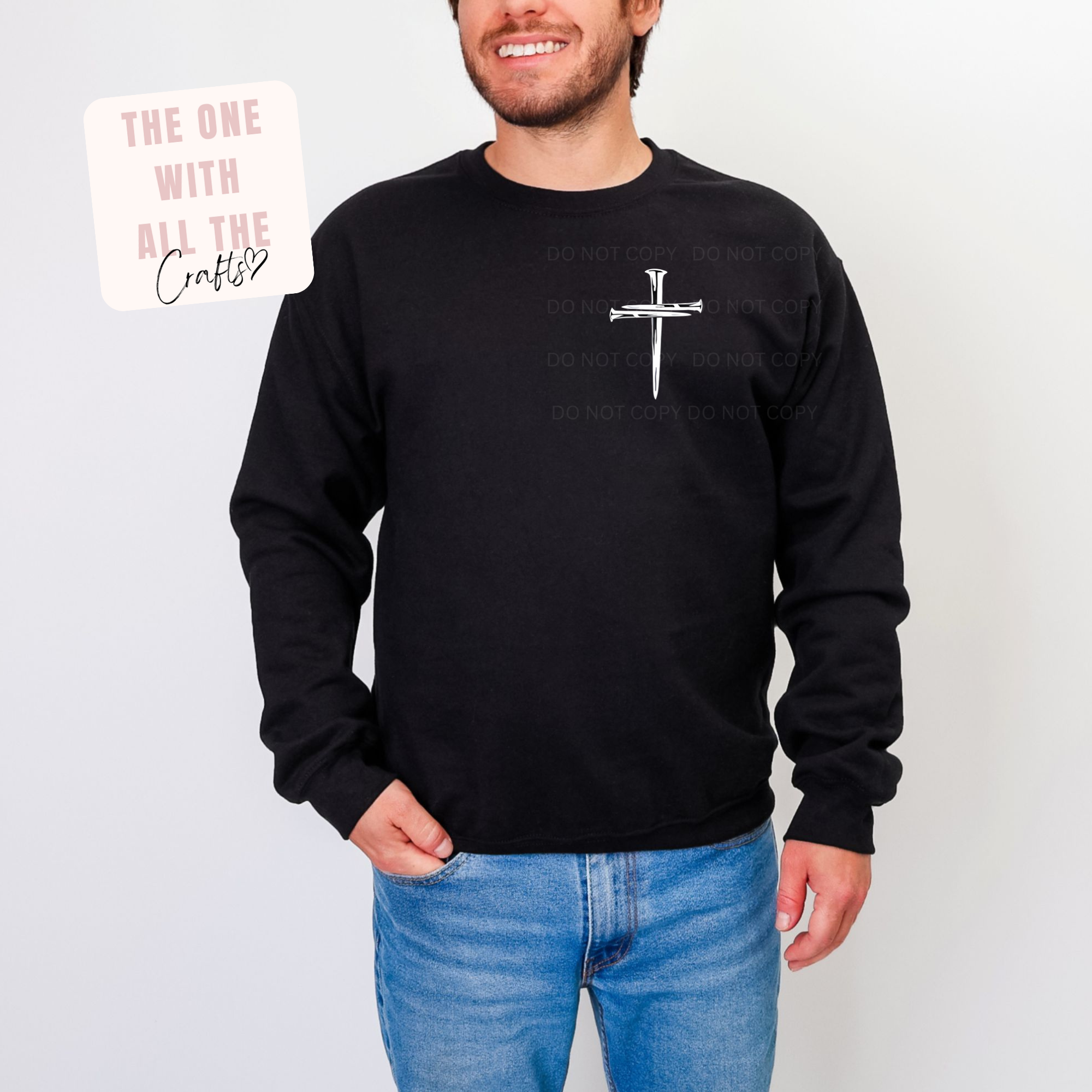 Person wearing a black sweatshirt with a white cross design on a plain background