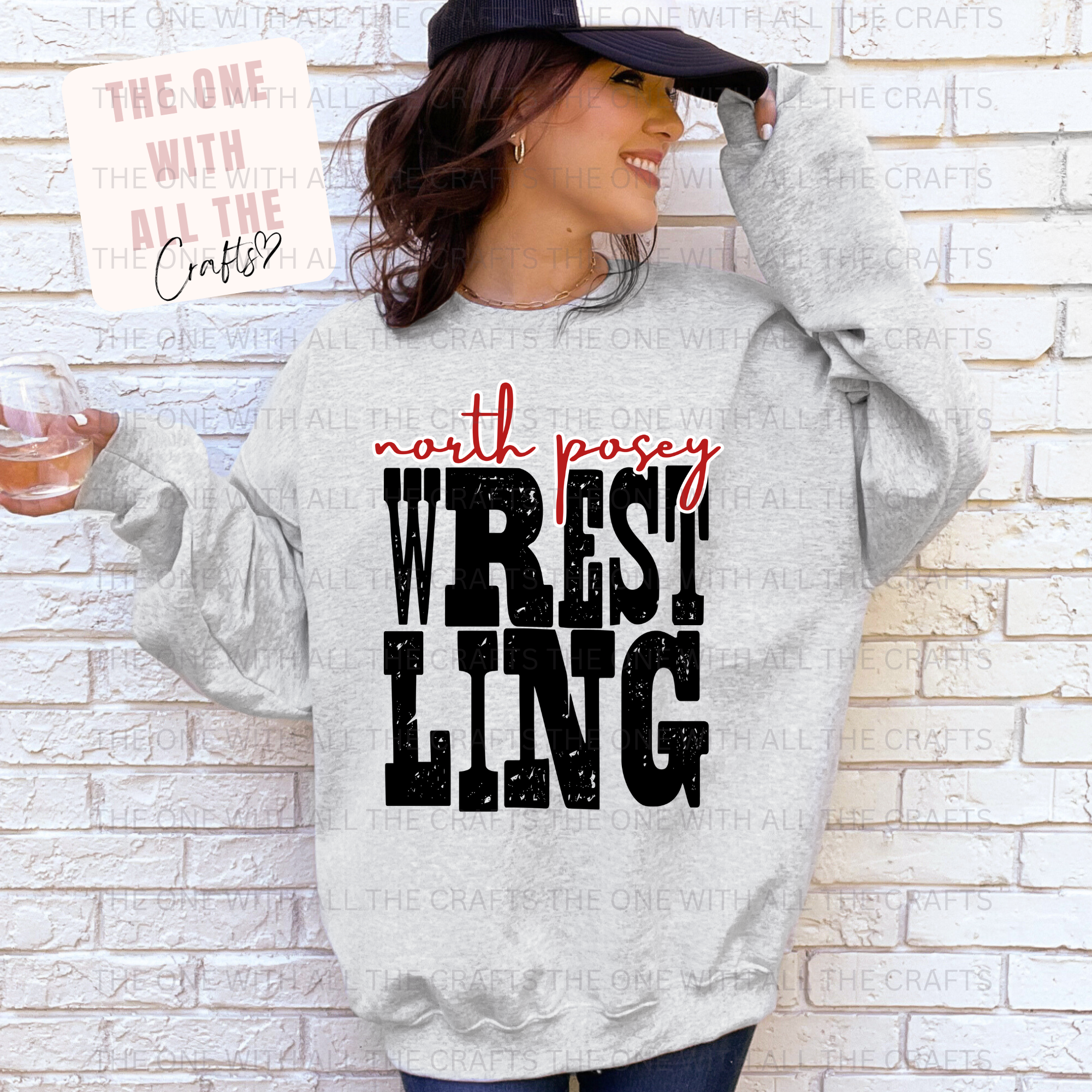 Person wearing a gray hoodie with 'north posey Wrestling' text against a brick wall.