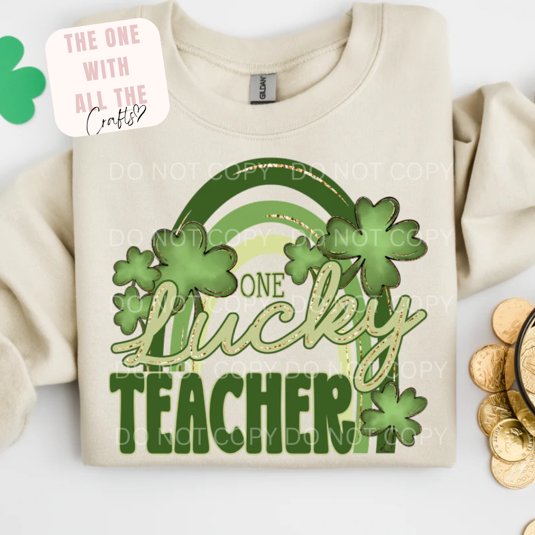 Beige sweatshirt with 'One Lucky Teacher' design featuring clovers on a white background.