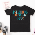 Black t-shirt with 'Preschool Dude' text and colorful graphics on a white background