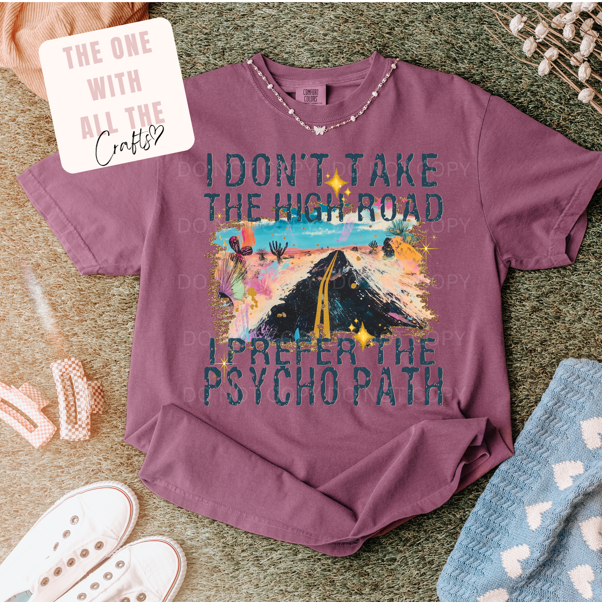 Purple t-shirt with graphic design and text on a textured surface
