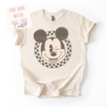 Beige t-shirt with a graphic of a character's face on a white background