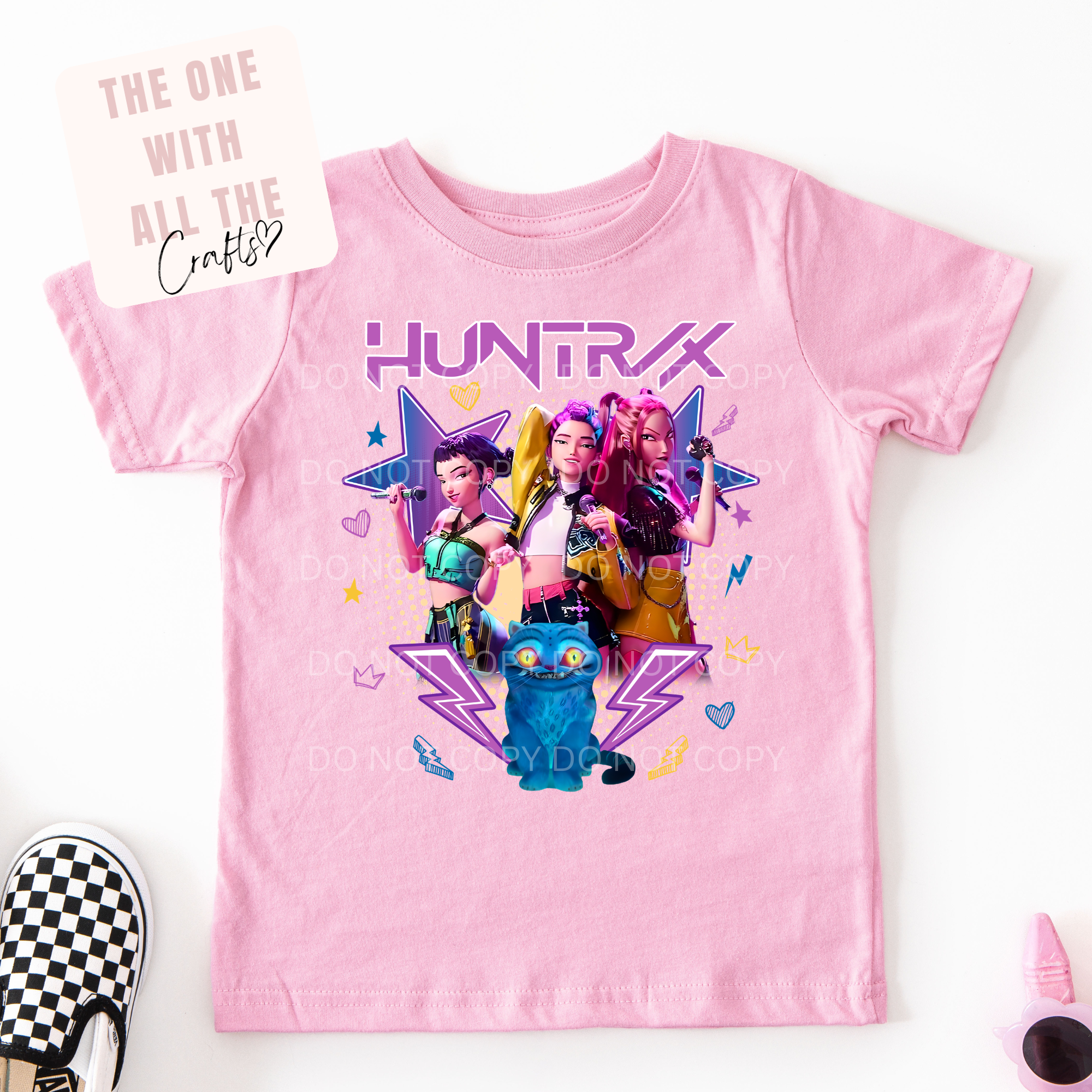 Pink t-shirt with cartoon characters and 'HUNTRAX' text on a white background