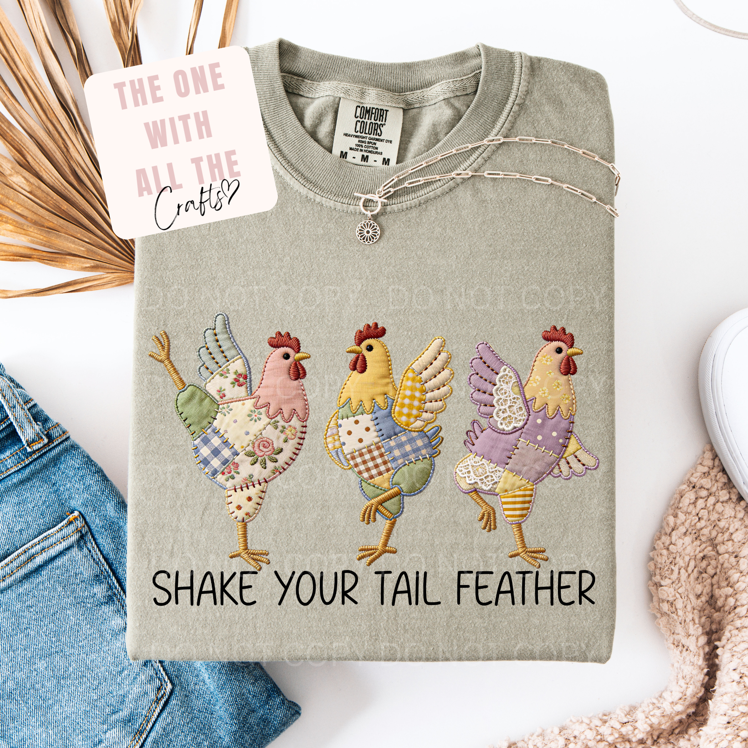 Gray sweatshirt with colorful chicken designs and text 'Shake Your Tail Feather' on a white background.