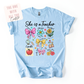 Light blue teacher t-shirt with colorful graphics and text on a white background