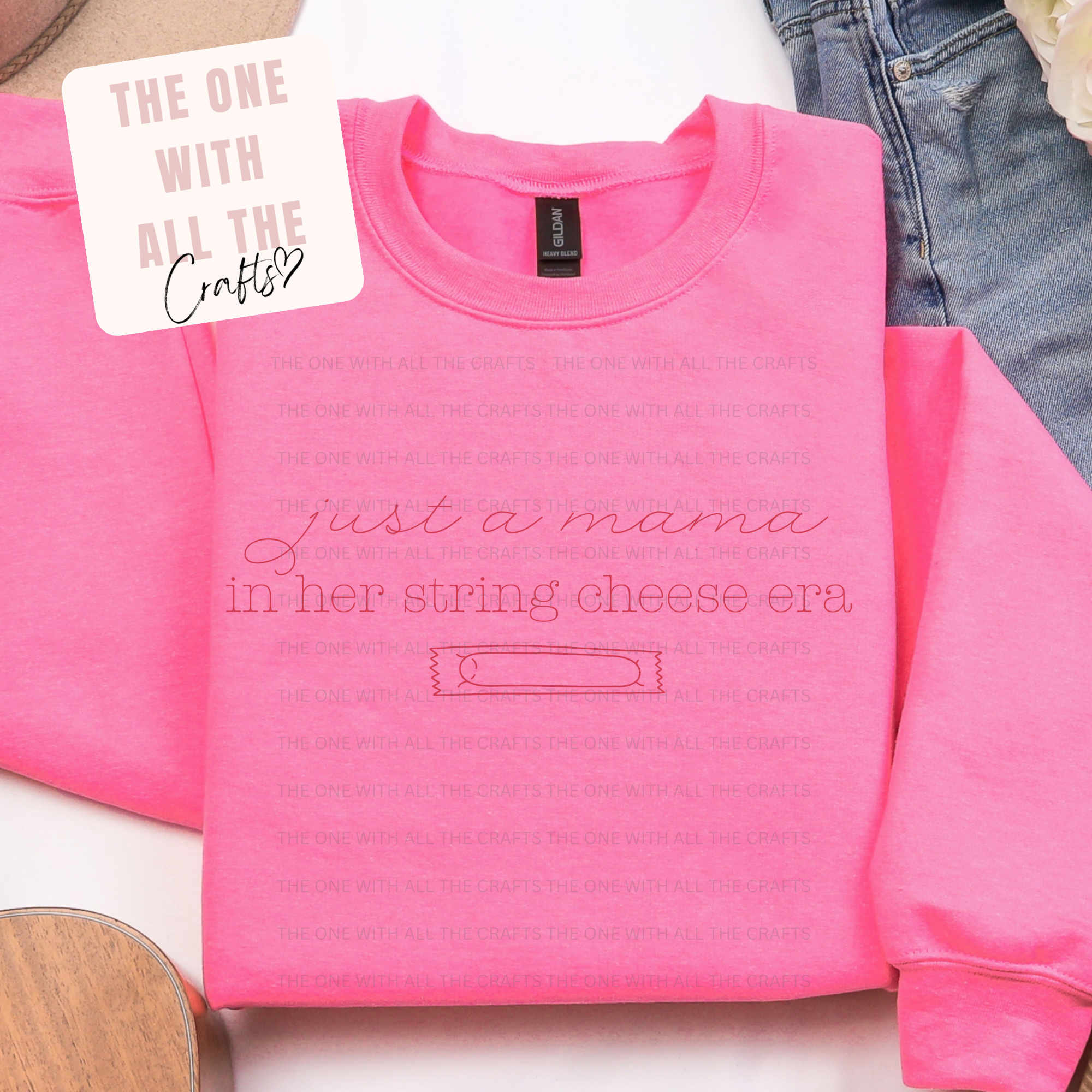 Pink sweatshirt with 'string cheese era' and a tag labeled 'The One with All the Crafts' on a white background. string cheese merch