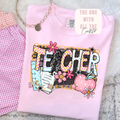 Pink sweatshirt with 'TEACHER' design on a textured surface