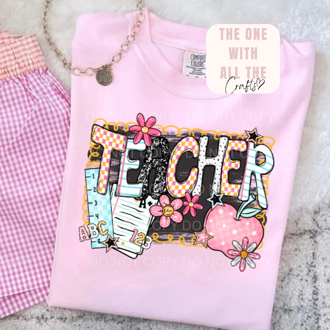 Pink sweatshirt with 'TEACHER' design on a textured surface